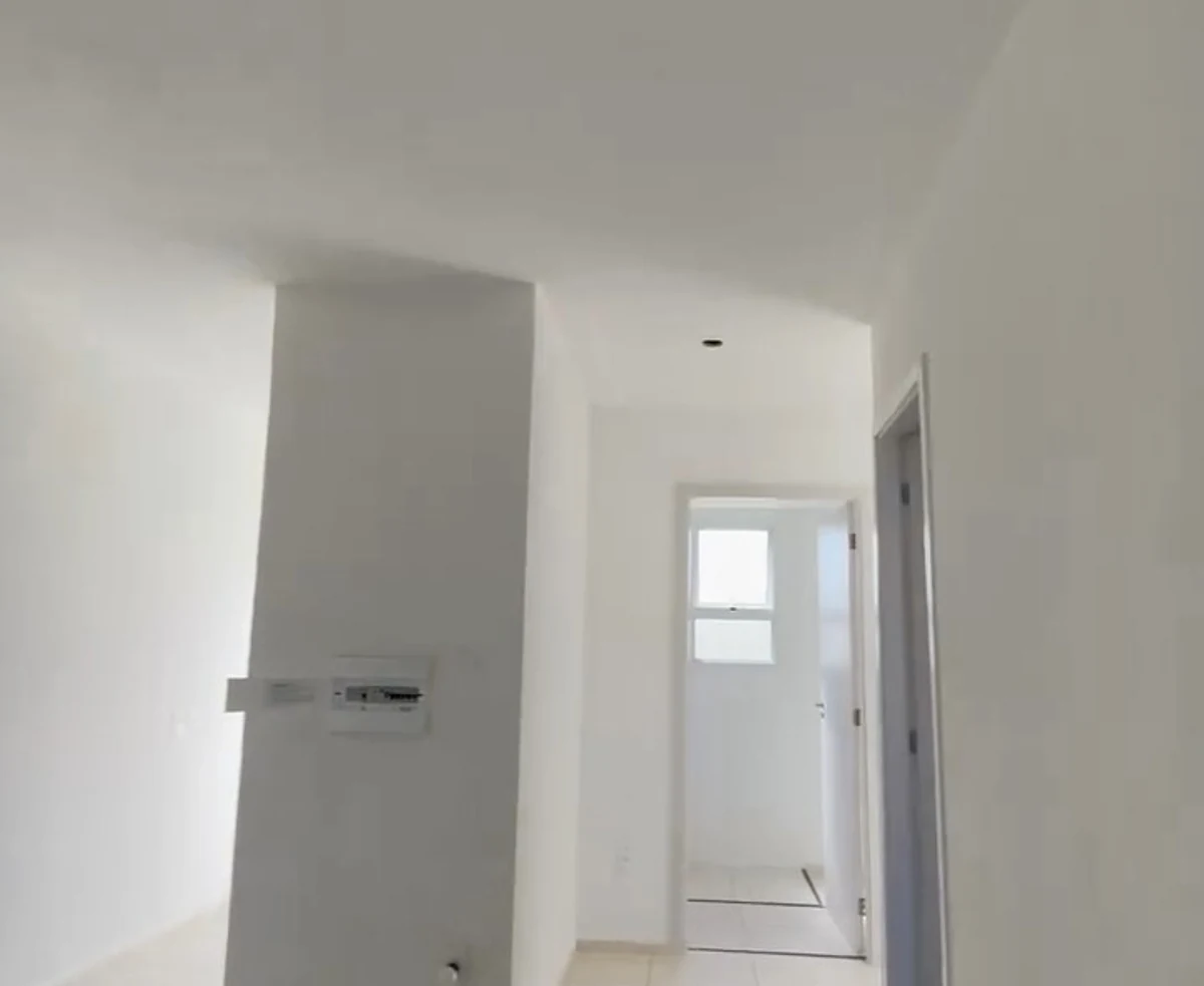 Apartamento novo e vazio: paredes brancas, laje lisa com um ponto de luz.