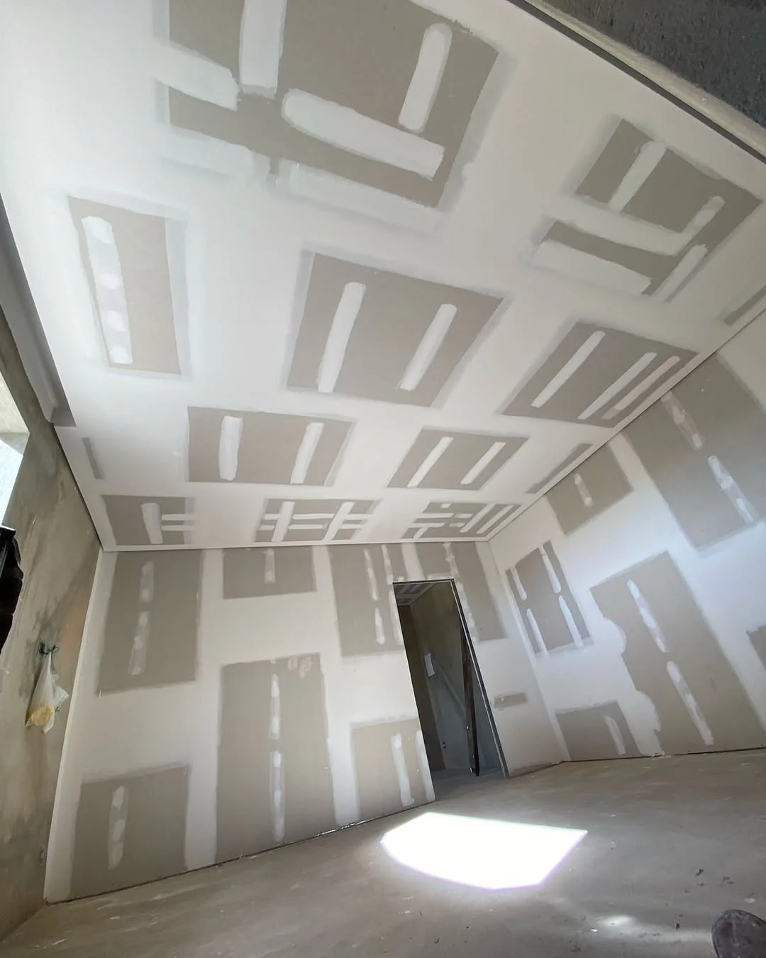 Teto e paredes em drywall com juntas rejuntadas, prontos para lixamento.